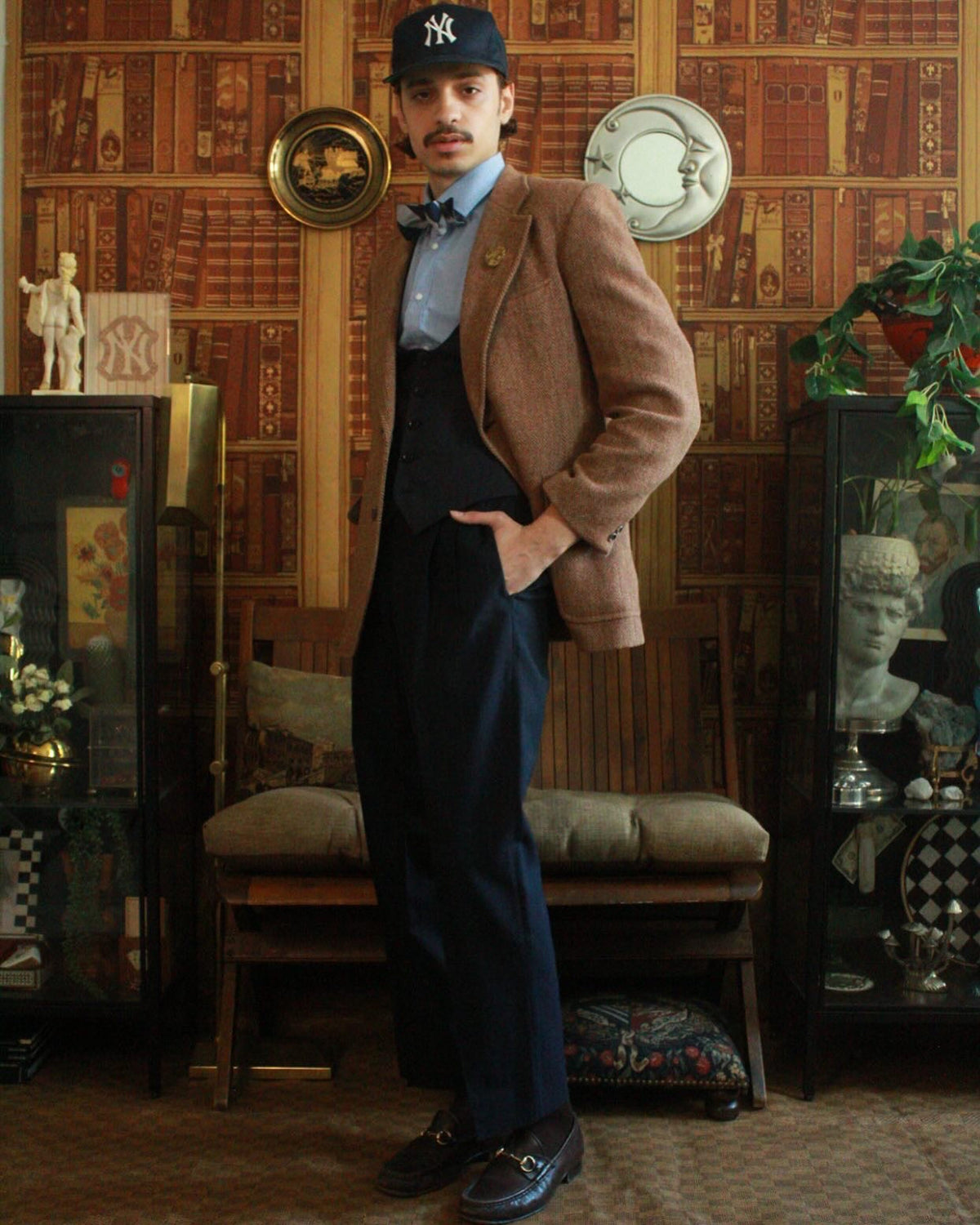 Vintage tweed blazer, NY Yankees cap, wide-leg navy trousers, library backdrop — Hommefound The Reading Room FW25