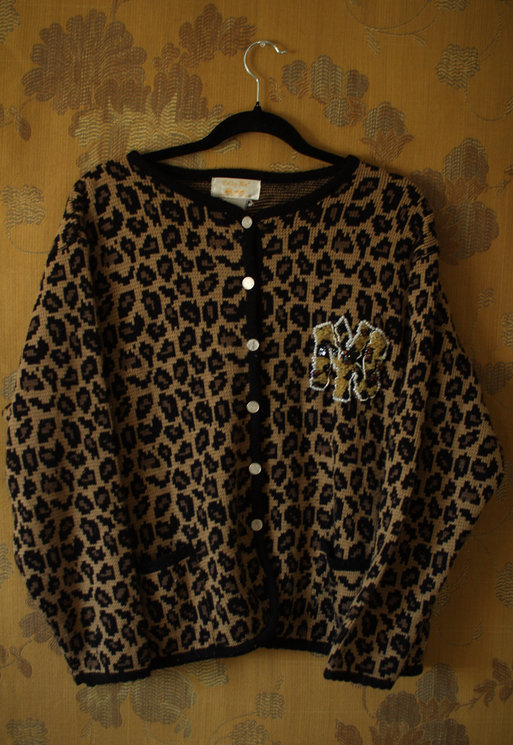 Vintage 1990s leopard print cardigan with hand-beaded chest detail, front view on hanger