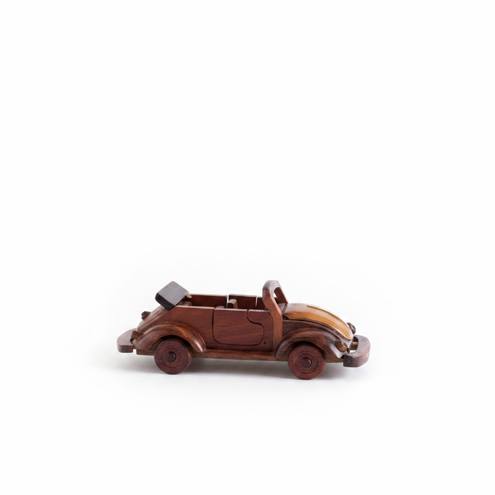 Vintage hand-carved wooden VW Beetle convertible model in mahogany on white background