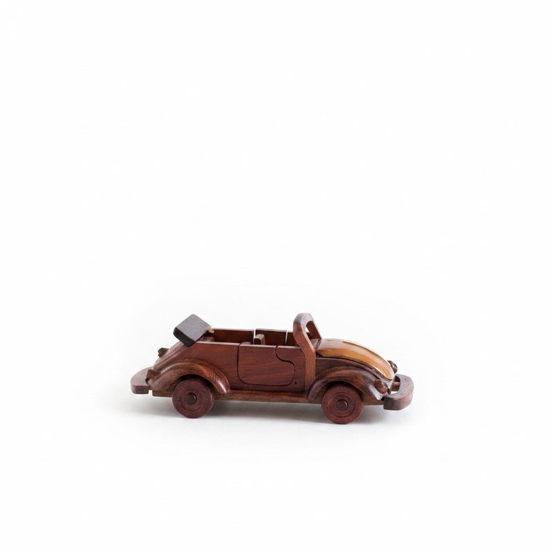 Vintage hand-carved wooden VW Beetle convertible model in mahogany on white background